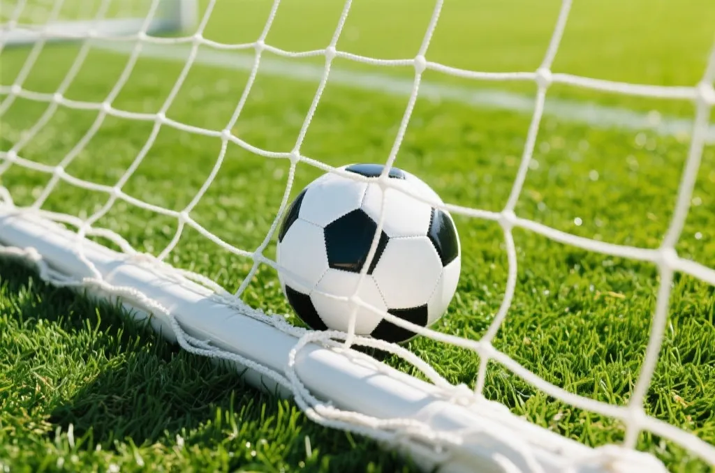 An editorial high-angle shot of a classic black and white soccer ball nestled in the white net of a goal on a sunny day, lush green turf